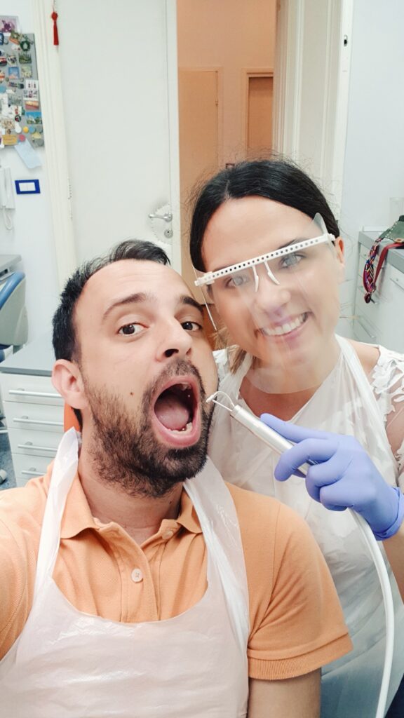 divertida foto de una dentista sonriendo y su paciente con la boca abierta