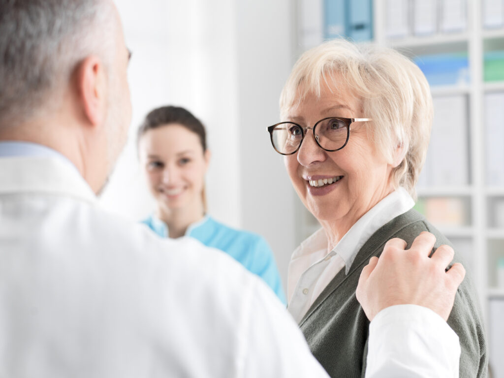 “Dentista evaluando la estabilidad de una prótesis dental en un paciente con pérdida ósea.”